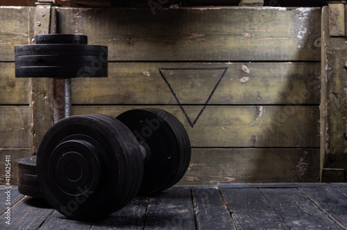 Black dumbbells on the background of a wooden box. Dumbbells and military and green box. photo