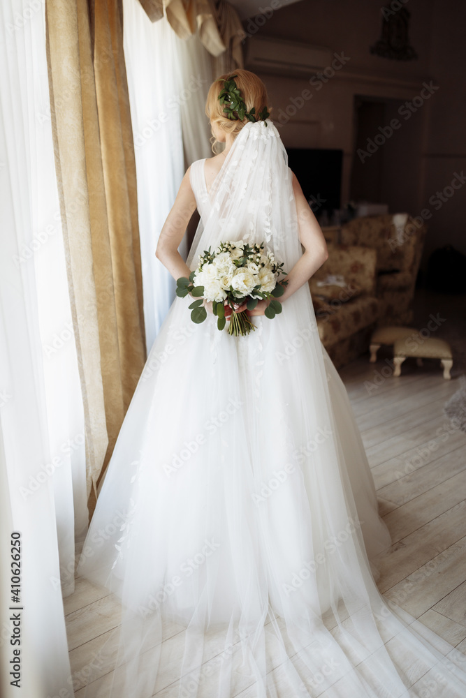 Beautiful bride portrait in wedding dress near window Beautiful bride portrait in wedding dress near window