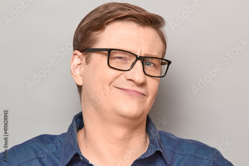 Portrait of happy confident blond mature man with glasses