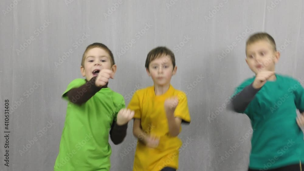 Three athletes in colorful T-shirts train blocks and punches Three athletes in colorful T-shirts train blocks and punches