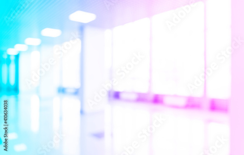 Blurred defocused bokeh background of exhibition hall or convention centre hallway. Blue and pink tones modern interior architecture. Abstract blur modern business office background