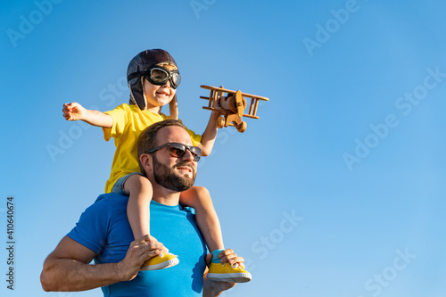 Father and son playing against blue summer sky background photo