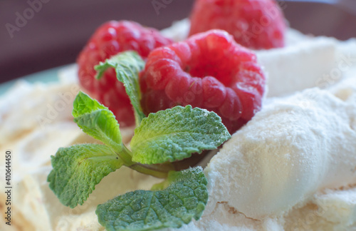 Dessert with fresh raspberries and mint on a plate. Kitchen table. Breakfast. Close-up. Soft focus in the background