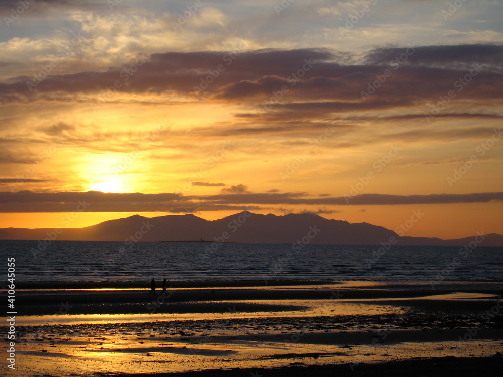 Dramatic sunset over Isle of Arran and Firth of Clyde seen from Prestwick beach