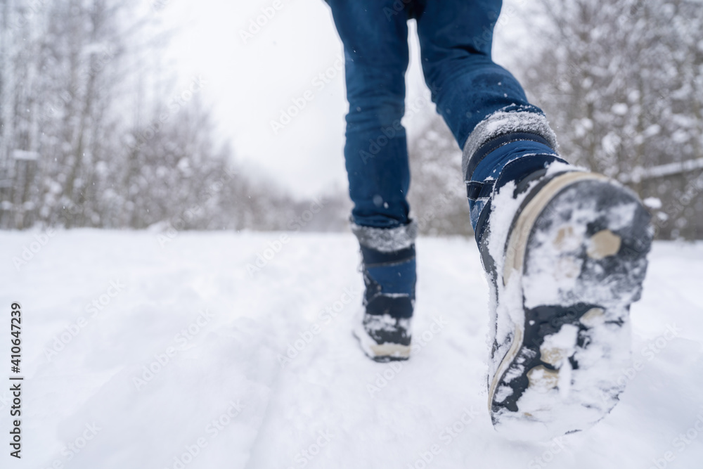 Walk in the park in winter on snow. Legs of a walking person Walk in the park in winter on snow. Legs of a walking person