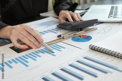 Fototapeta Naklejka Na Ścianę i Meble -  Asian businesswoman hands hold documents with financial statistic stock photo,discussion and analysis data the charts and graphs. Finance concept
