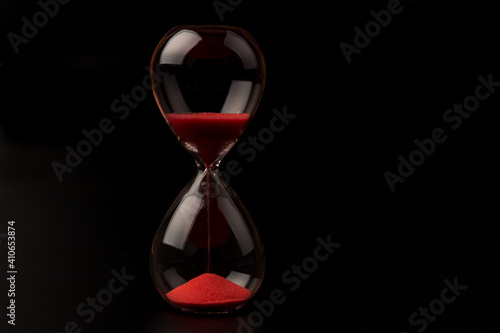 Crystal hourglass on black background as a concept of passing time for business term, urgency and outcome of time.