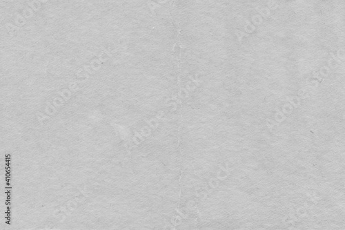 Cardboard gray texture close-up. Light old paper background. Grunge concrete wall. Vintage blank wallpaper.