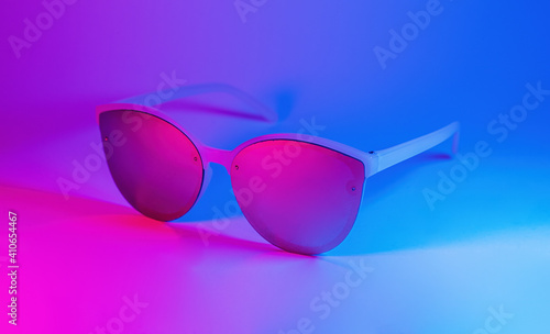 Sunglasses in vibrant bold gradient purple and blue holographic colors. Concept art. Minimal summer surrealism
