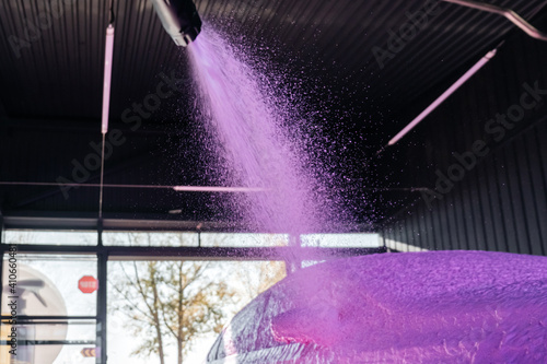 car wash with a spray of pink foam from a pistol