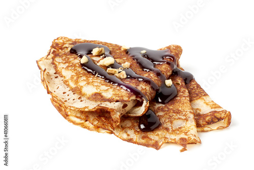 Stack of folded crepes with chocolate sauce on white