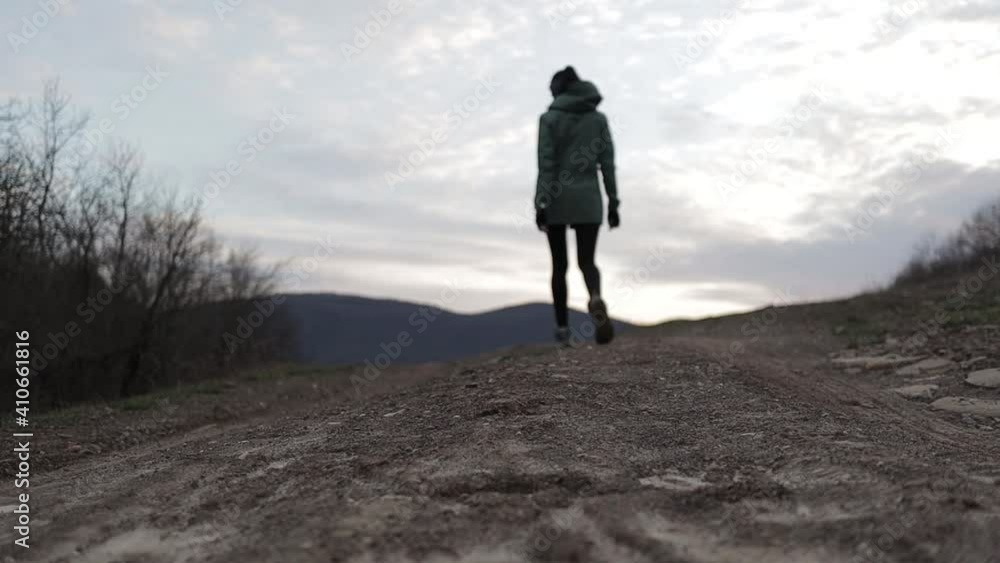 the girl goes up the hill, back from the camera the girl goes up the hill, back from the camera