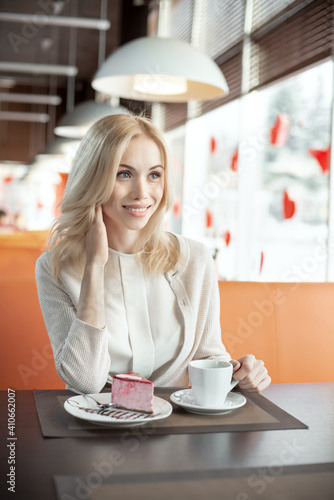 Very beautiful happy young woman, sit in cafe and drink coffee