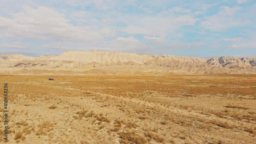 Side view off road 4wd vehicle driving in deserted landscape with beautiful caucasus Vashlovani landscape Side view off road 4wd vehicle driving in deserted landscape with beautiful caucasus Vashlovani landscape