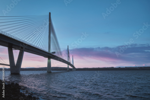 A view of a large three-tower cable-stayed bridge at sunrise. Queensferry Crossing Bridge, Scotland, United Kingdom