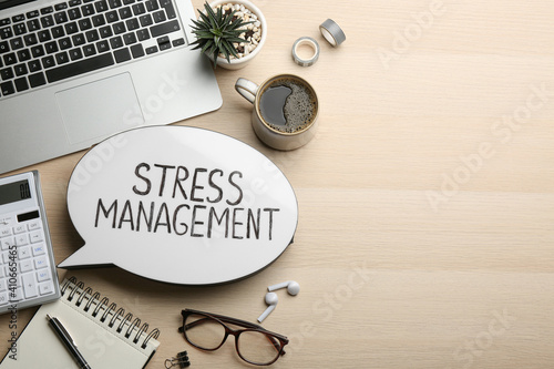 Flat lay composition of speech bubble lightbox with phrase Stress Management on wooden table. Space for text