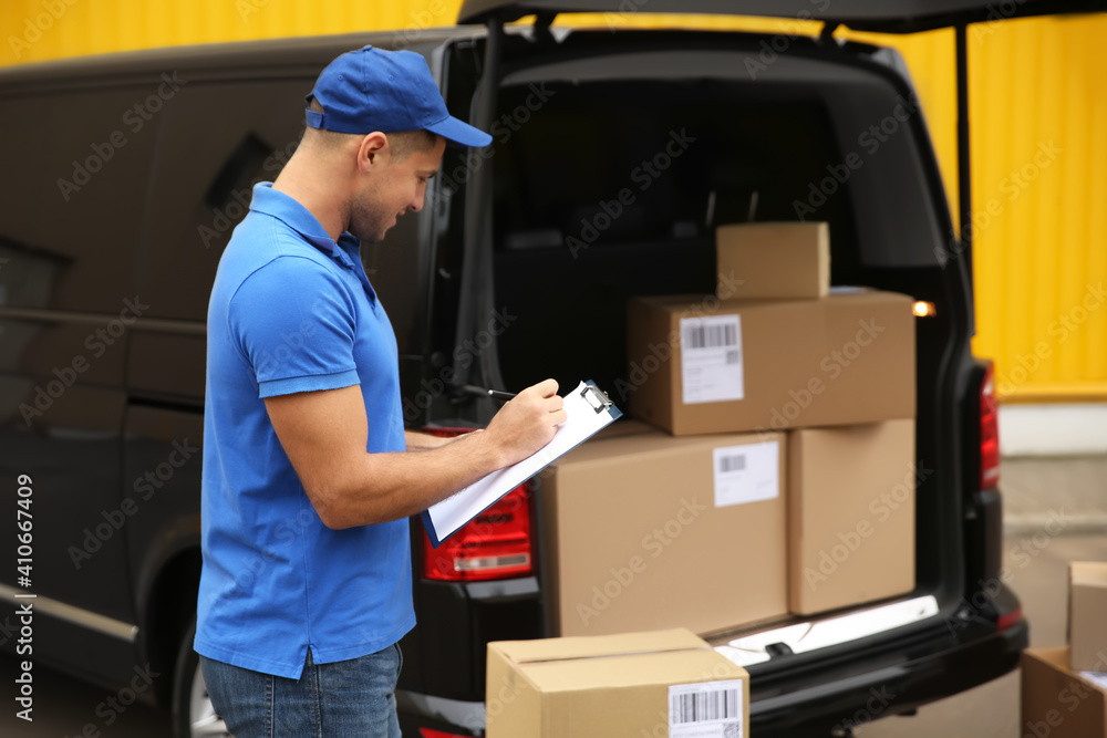 Courier with clipboard near delivery van outdoors Courier with clipboard near delivery van outdoors