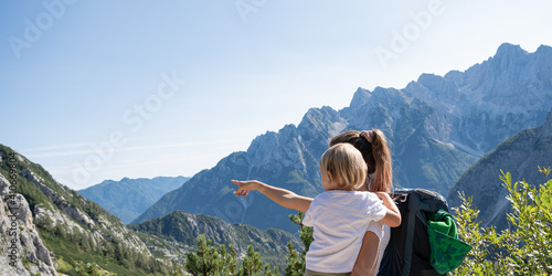 Mother holding her toddler child showing her beautiful view of mountains