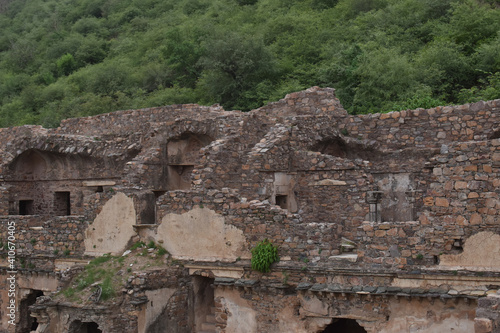 Ruins of an old building near a green forest in Bhangarh village, Rajgarh Alwar, Rajasthan, India photo