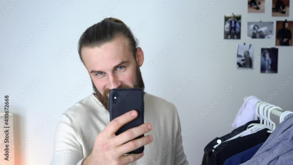 Attractive Young long hair guy is looking in a mirror doing selfie Attractive Young long hair guy is looking in a mirror doing selfie