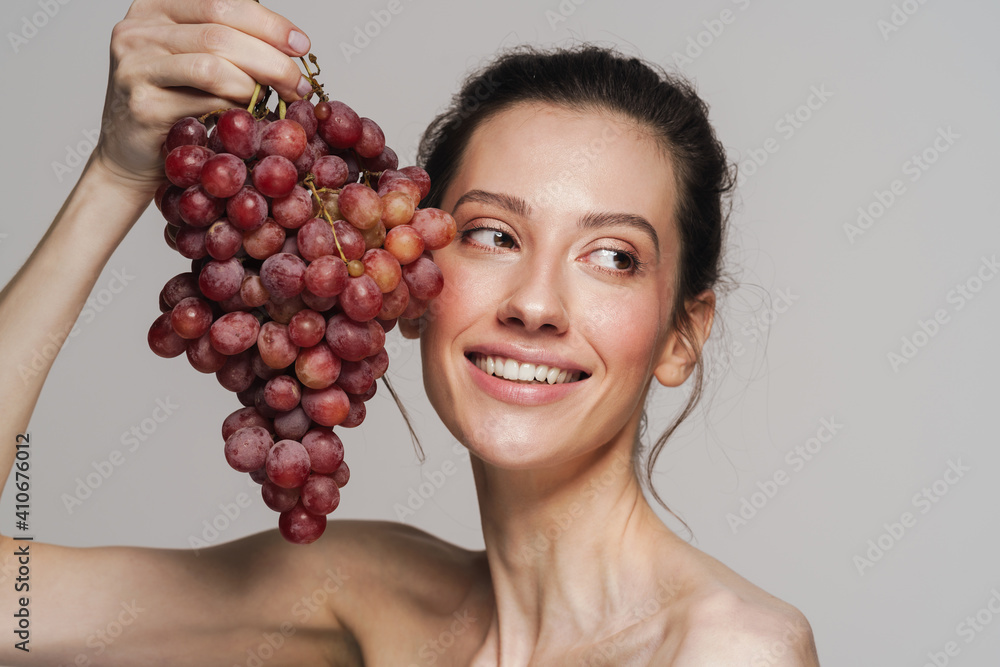 Smiling half-naked woman posing with bunch of grapes Smiling half-naked woman posing with bunch of grapes