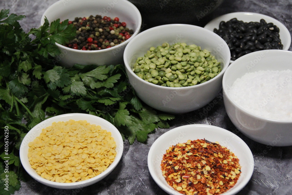 colorful spices and legumes, fresh parsley and stone mortar, pepper, hot pepper, coarse rock salt, black beans and yellow lentils, and colored pepper colorful spices and legumes, fresh parsley and stone mortar, pepper, hot pepper, coarse rock salt, black beans and yellow lentils, and colored pepper