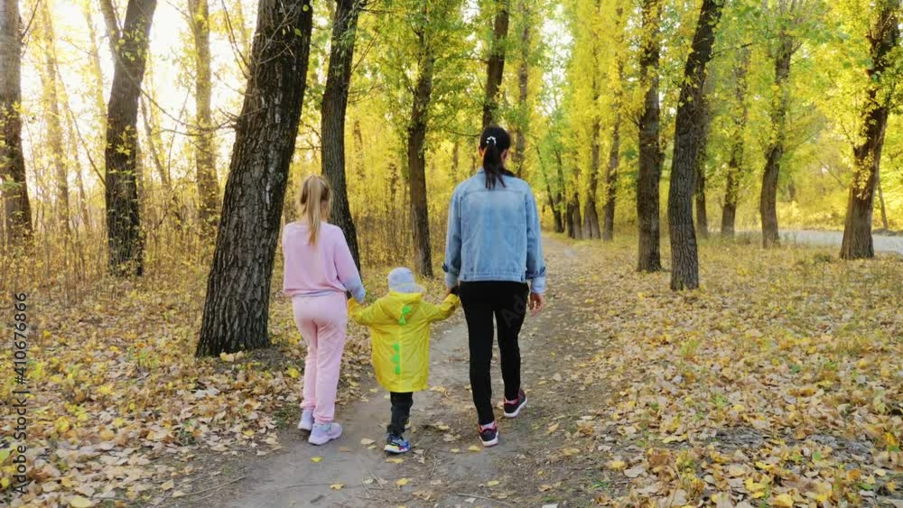 Beautiful young woman with two children walking in forest. Beautiful young woman with two children walking in forest.