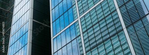 modern high rise buildings with reflections of blue sky and clouds