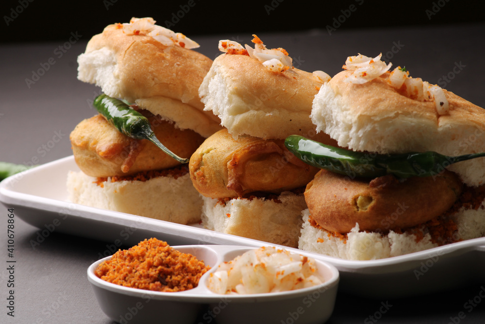 Bombay vada paav is an indian burger. Potato patty is deep fried in gram flour or besan batter and it is served hot with paav or bun like sandwich. Its available and liked all over India Bombay vada paav is an indian burger. Potato patty is deep fried in gram flour or besan batter and it is served hot with paav or bun like sandwich. Its available and liked all over India