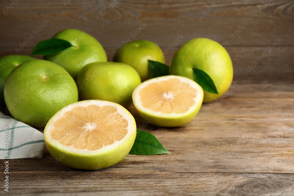 Whole and cut sweetie fruits on wooden table, space for text Whole and cut sweetie fruits on wooden table, space for text