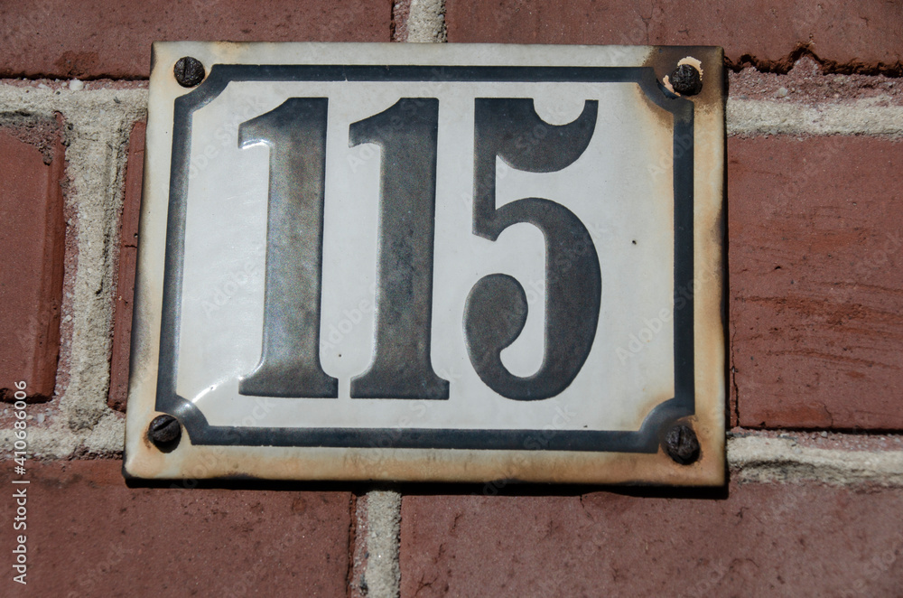 Schild mit einer Hausnummer -einhundertfünfzehn - 115 Schild mit einer Hausnummer -einhundertfünfzehn - 115