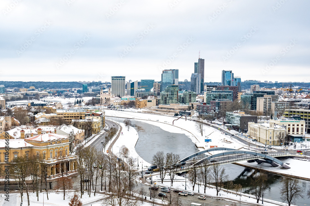 Obraz premium Vilnius, capital of Lithuania, beautiful scenic aerial panorama of modern business financial district architecture buildings with snow, Neris river and bridge in winter