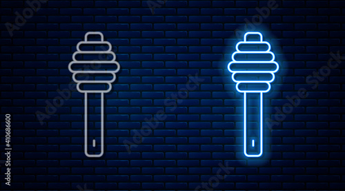 Glowing neon line Honey dipper stick icon isolated on brick wall background. Honey ladle. Vector.