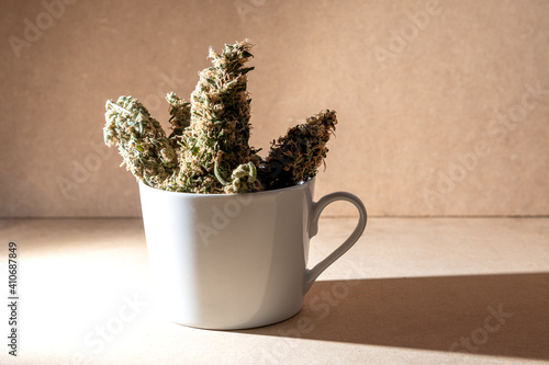 Medical marihuana buds inside a coffee cup. Selective focus.