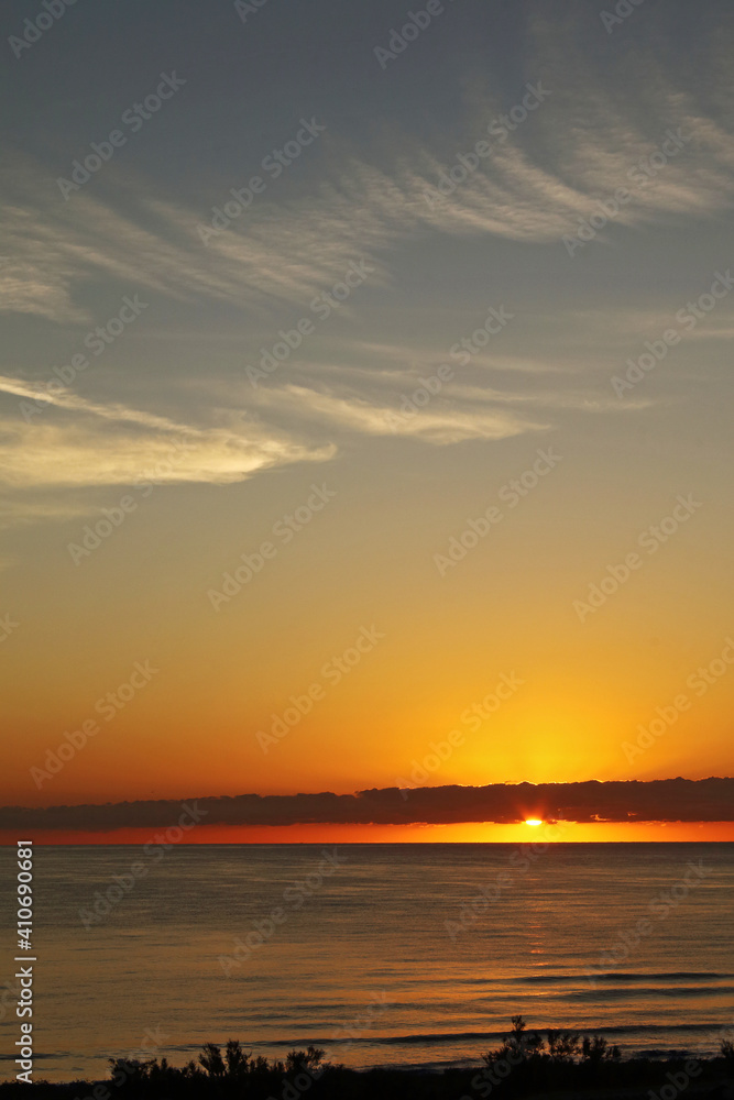 A golden sunrise on the beach, summer morning.