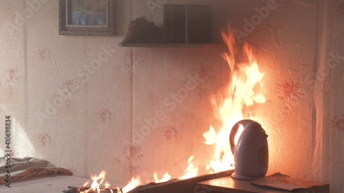 The bedroom is on fire with a lot of smoke. The bed, bedside table, plastic teapot, wallpaper and bookshelves are in flames in a residential home. Cinematic shot of aftermath of a two alarm fire 4k