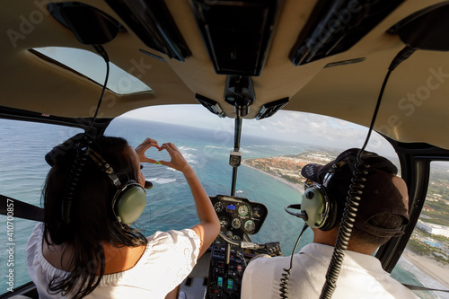 Winter getaway to summer time in Punta Cana Dominican Republic a girl flying in a helicopter and making a heart sign
