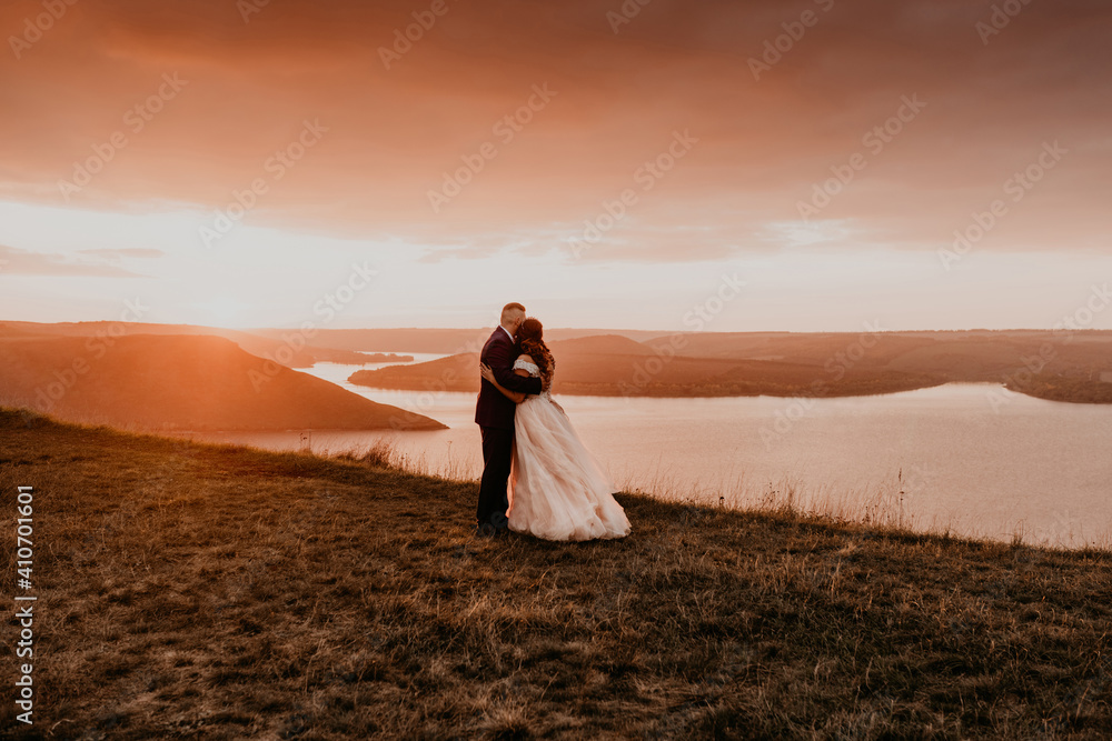 loving couple wedding newlyweds walk in tsummer in the fall on mountain above the river. sunset.