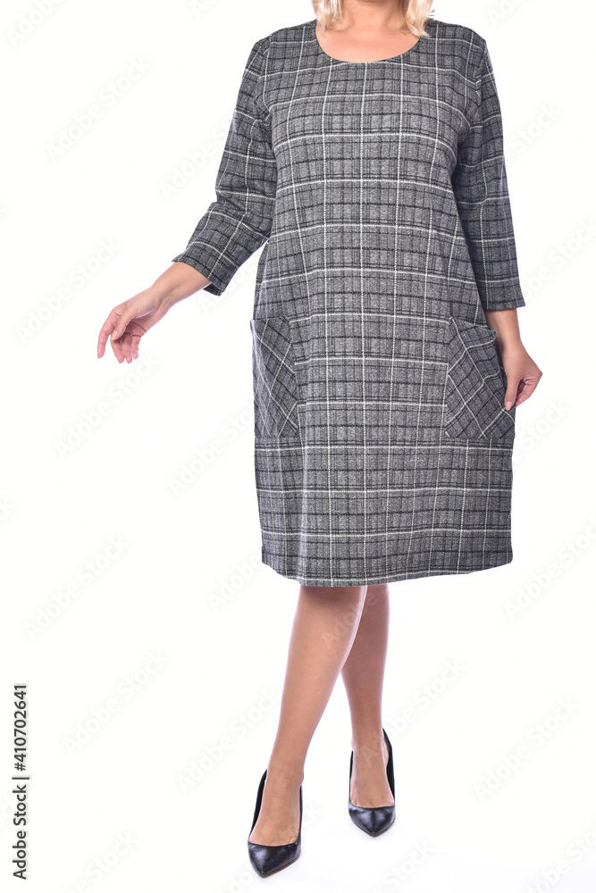 Plus size woman in a gray dress in a cage on a white background.