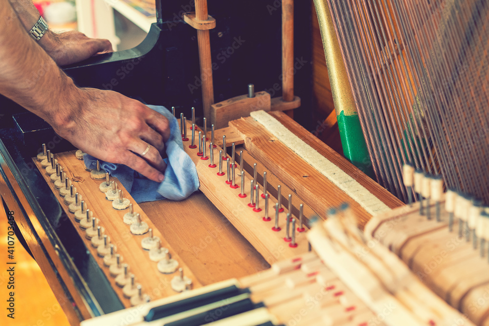 Setting up an old piano. The master repairs an old piano. Deep cleaning the piano. Hands of professional worker repairing and tuning an old piano. toned