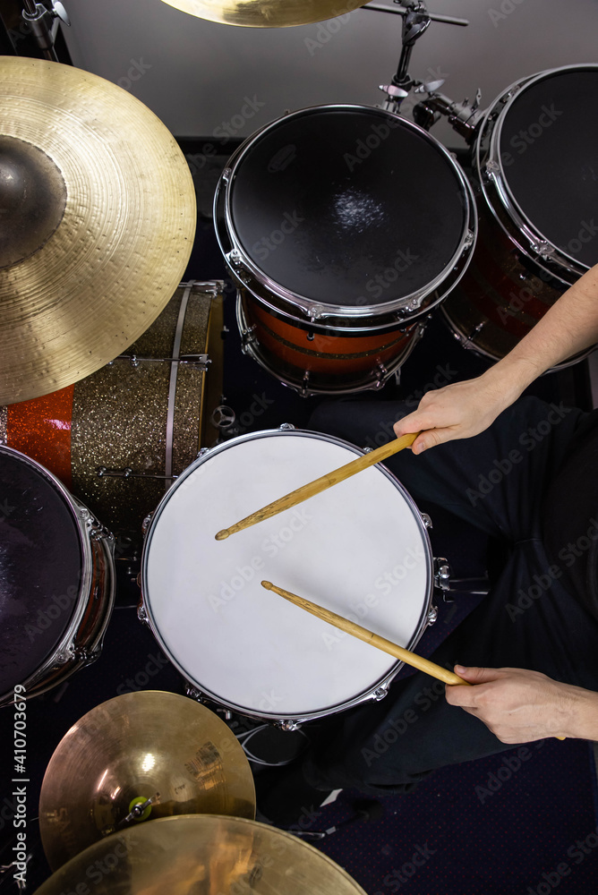 Obraz premium Professional drum set closeup. Man drummer with drumsticks playing drums and cymbals, on the live music rock concert or in recording studio