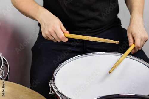 Professional drum set closeup. Man drummer with drumsticks playing drums and cymbals  on the live music rock concert or in recording studio    