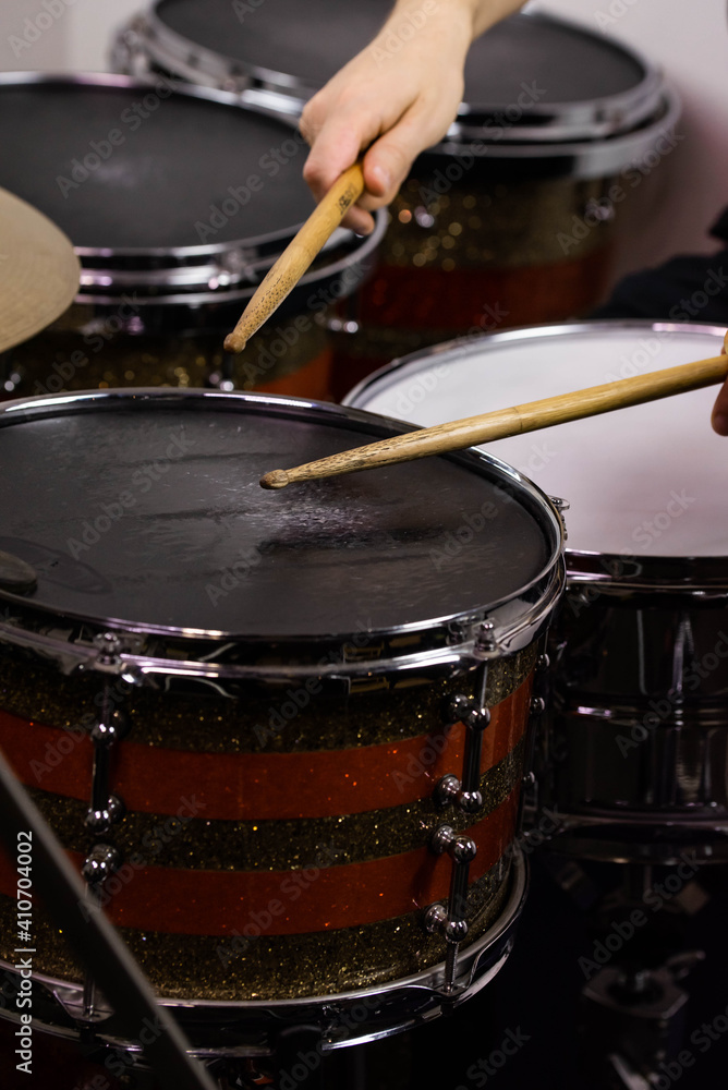 Obraz premium Professional drum set closeup. Man drummer with drumsticks playing drums and cymbals, on the live music rock concert or in recording studio