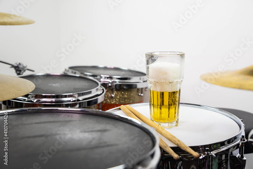 Photography Glass of light beer on professional drum set closeup