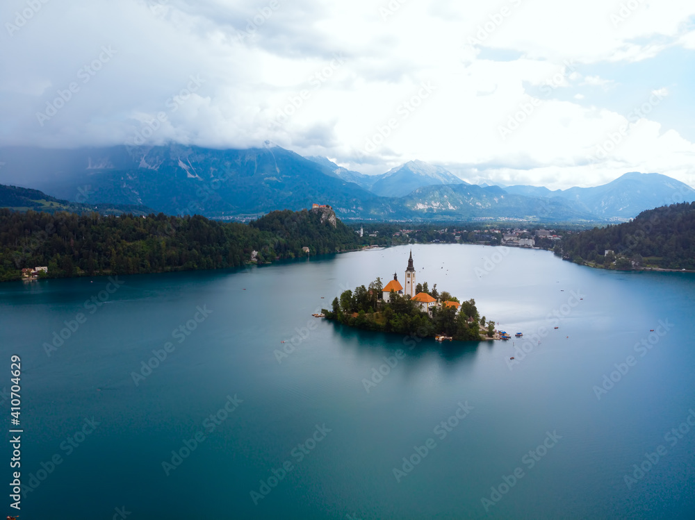 Aerial panoramic view of Lake Bled. Cloudy weather, heavy thunderstorm clouds on the horizon. Summer day. Church of the Assumption of Mary the Mother of God, Slovenia, Europe