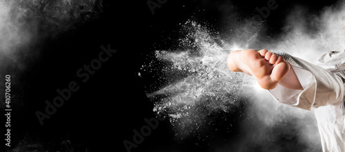 Woman in kimono practicing taekwondo on black background. Sports banner