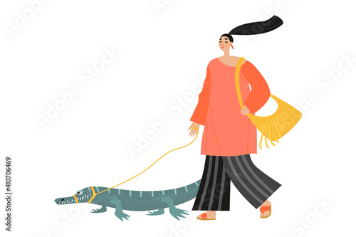 Funny girl walks with a crocodile on a leash.