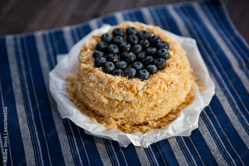 homemade cake decorated with crumbs and blueberries on a dark background