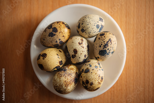 quail eggs in a plate stand on the table surface indoors.