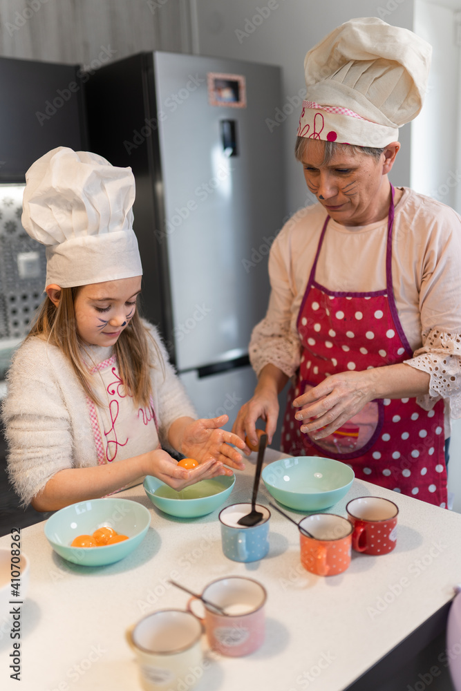 Grandmother and granddaughter preparing doughnuts at home Grandmother and granddaughter preparing doughnuts at home